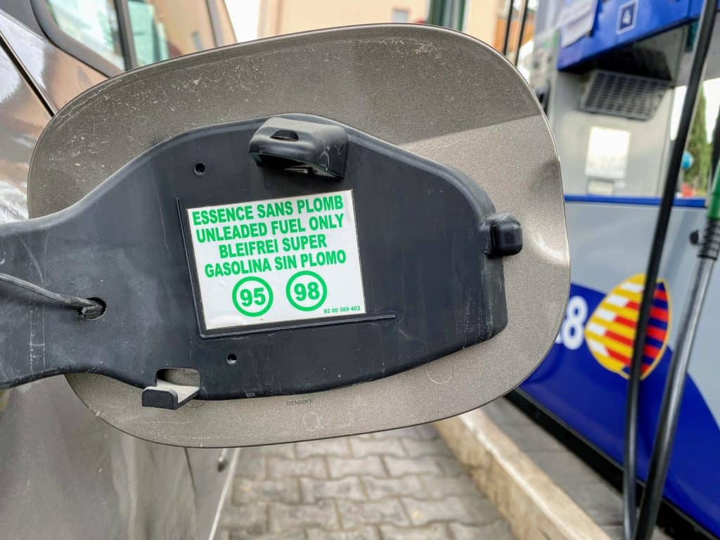 Inside lid to gas tank showing green text which means put in benzina, not gasolio at the Italian gas station.