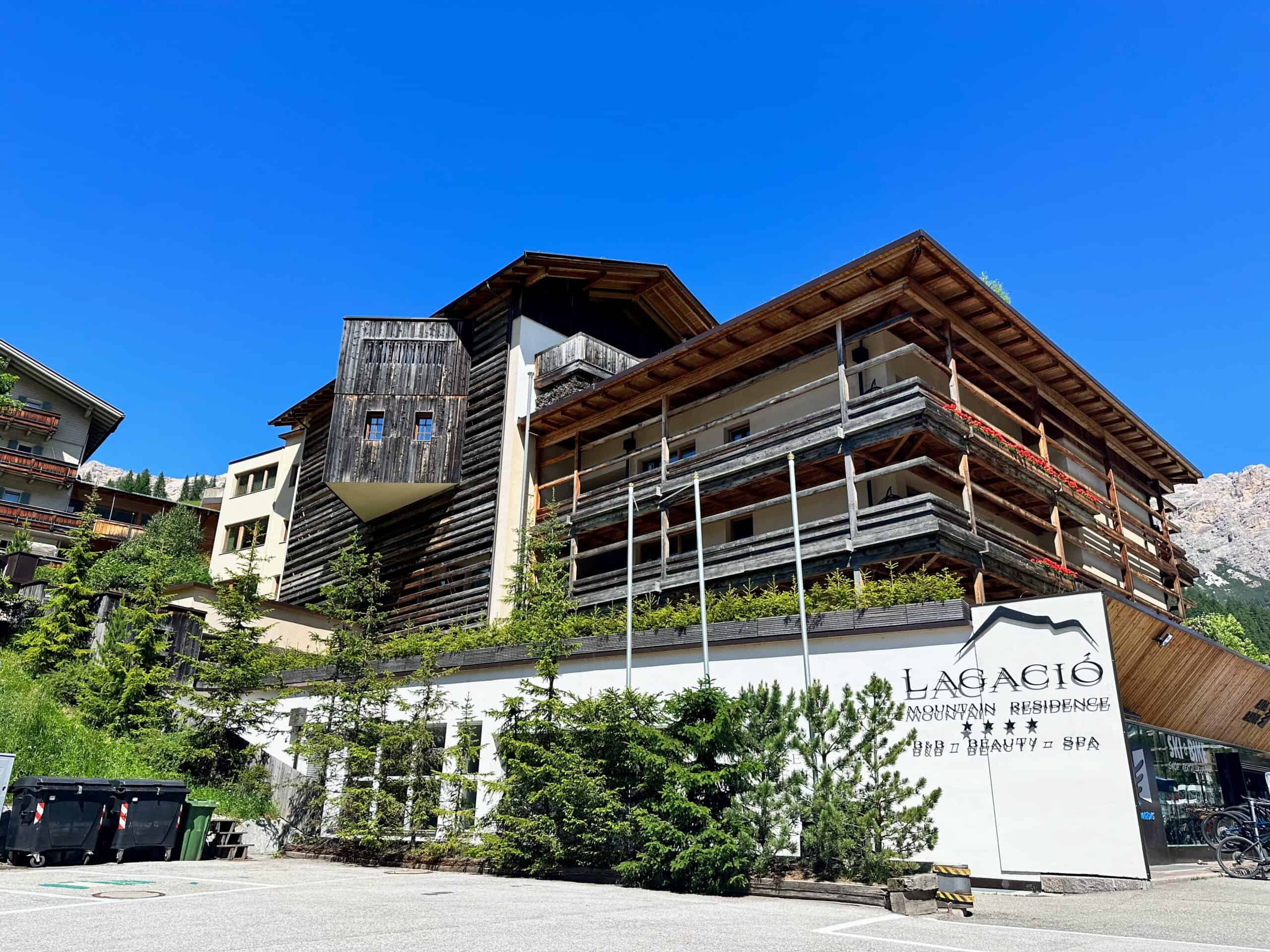 Wooden hotel with sign for Lagació. You can barely see mountains in background on right.