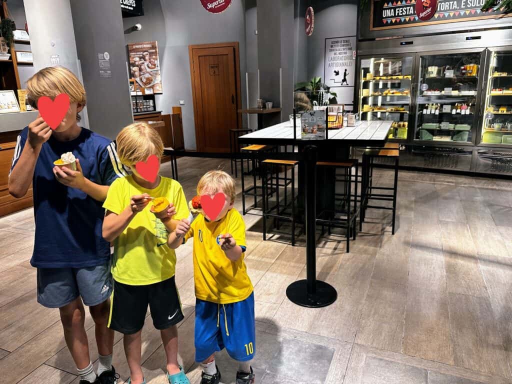 Three boys eating gelato inside a gelateria in Lecce, Puglia.