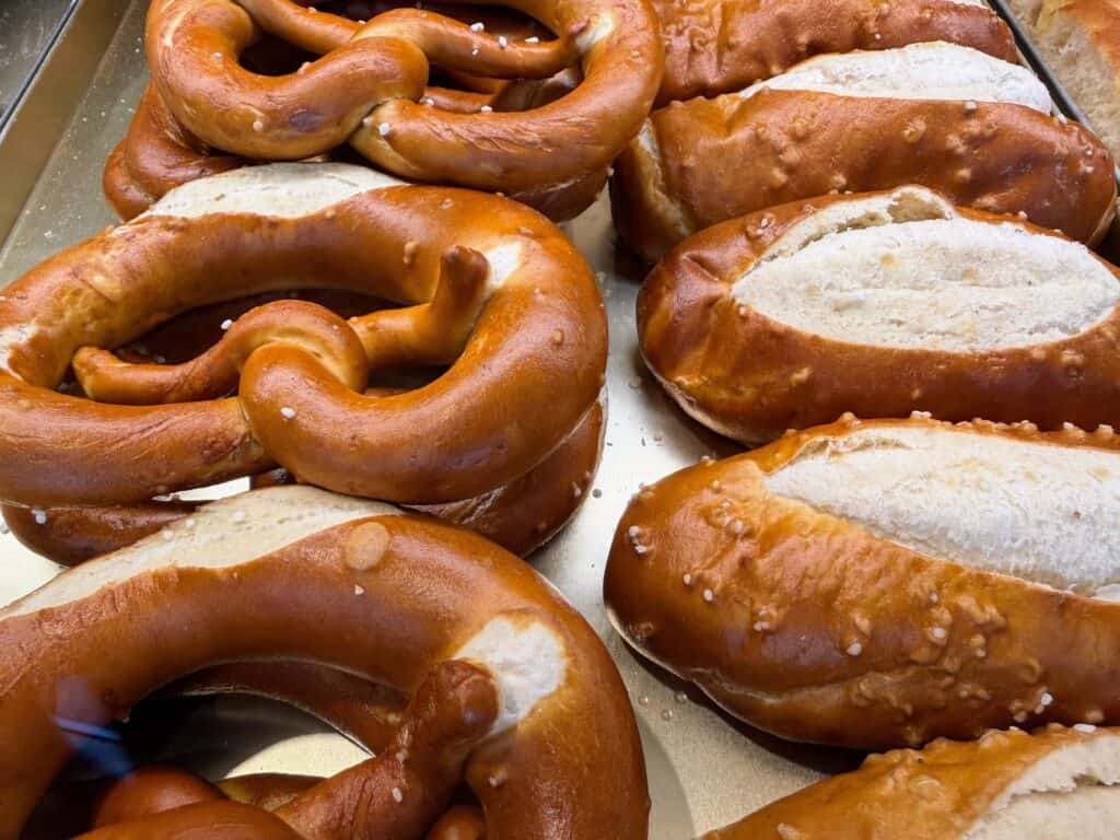 Pretzels and pretzel bread on metal trays. They are on display at a bakery in Vipiteno, Dolomites, Italy.